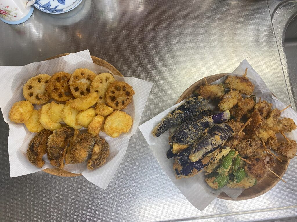 レンコン、ジャガイモ、シイタケの串カツが木皿に並んでいます。
豚肉のシソ巻き、1口豚肉、ナス、ピーマンの串カツが木皿に並んでいます。