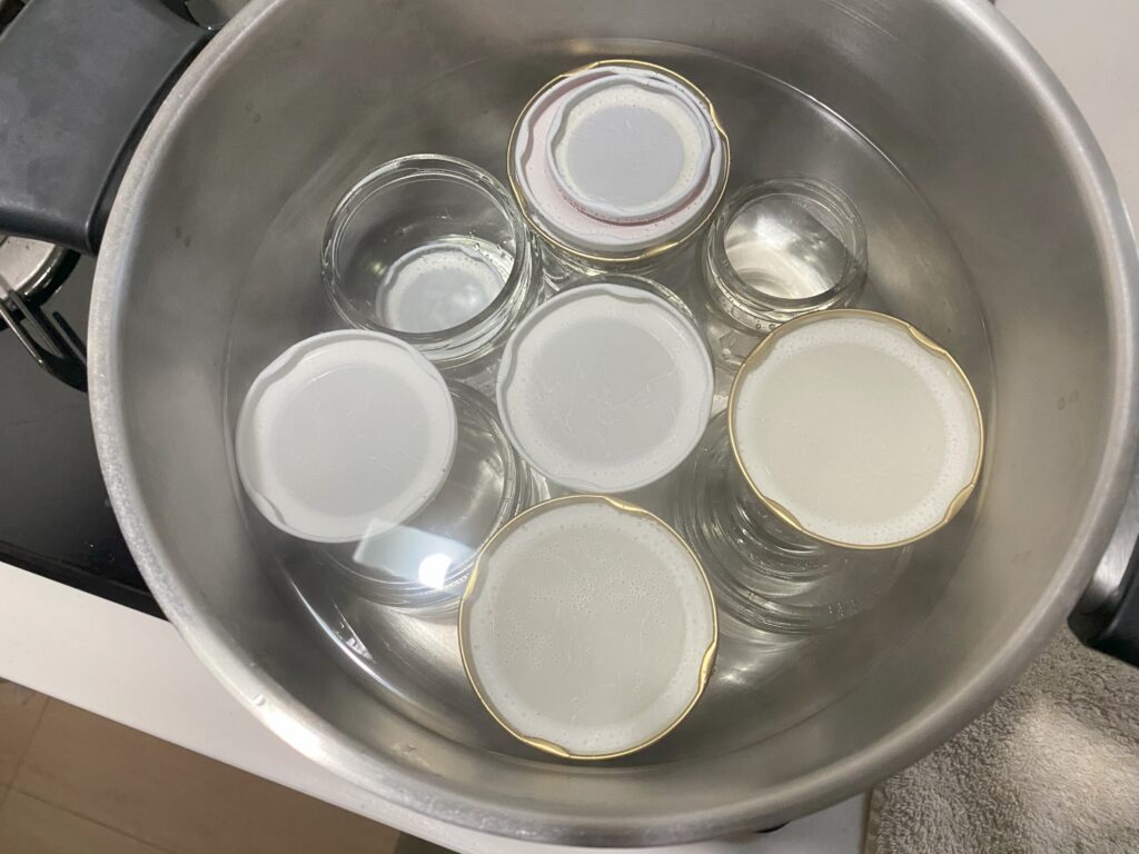 水を貼った鍋の中に瓶と蓋が入っています