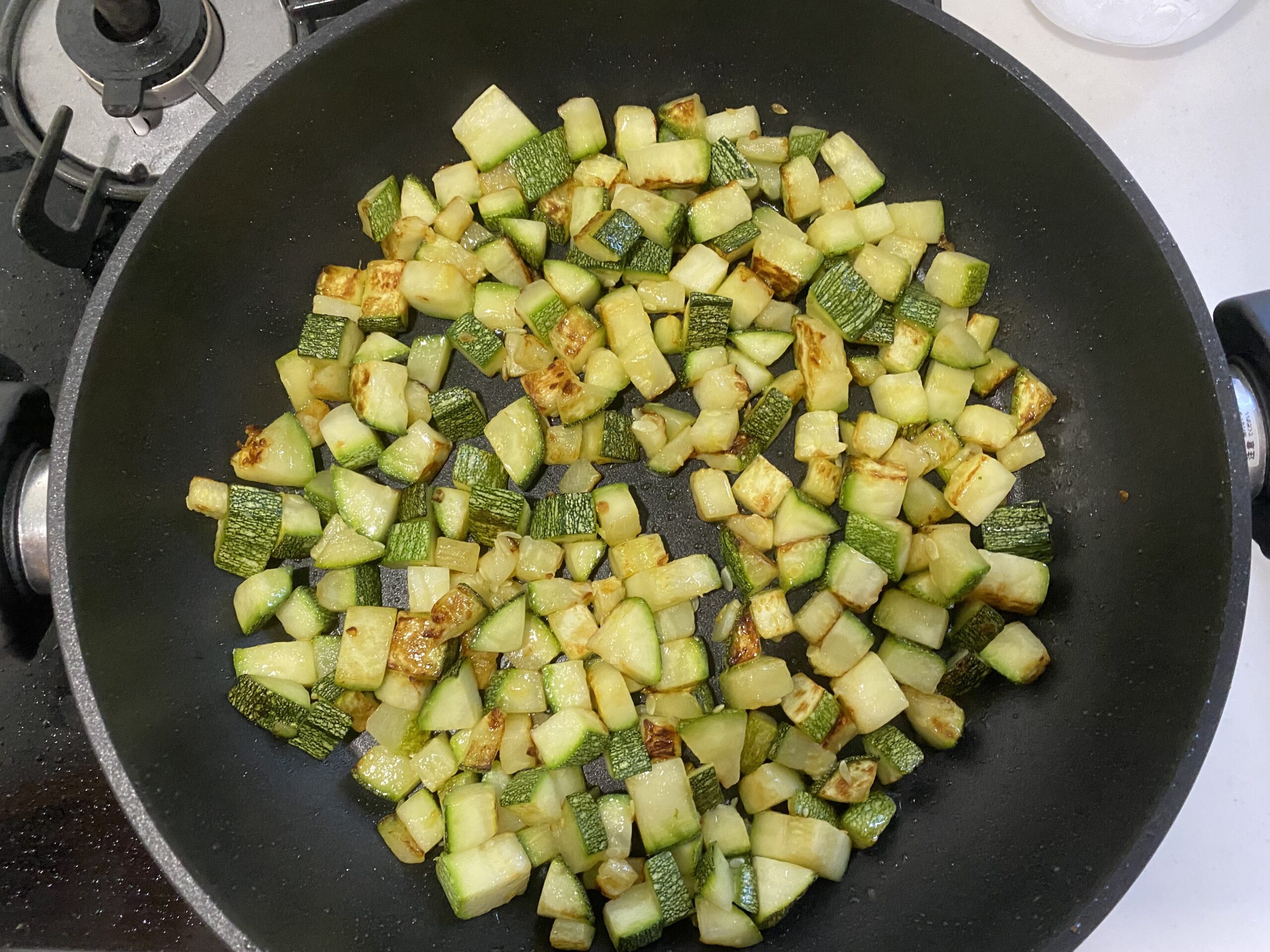 オリーブオイルで夏野菜を炒めている様子